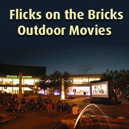Nicollet Commons Park at night. People watch a movie on a large inflatable screen.