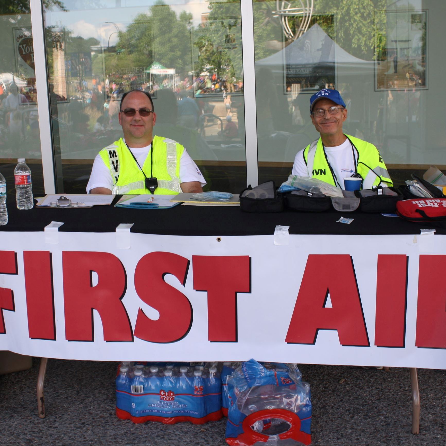 Volunteers sitting at first aid table