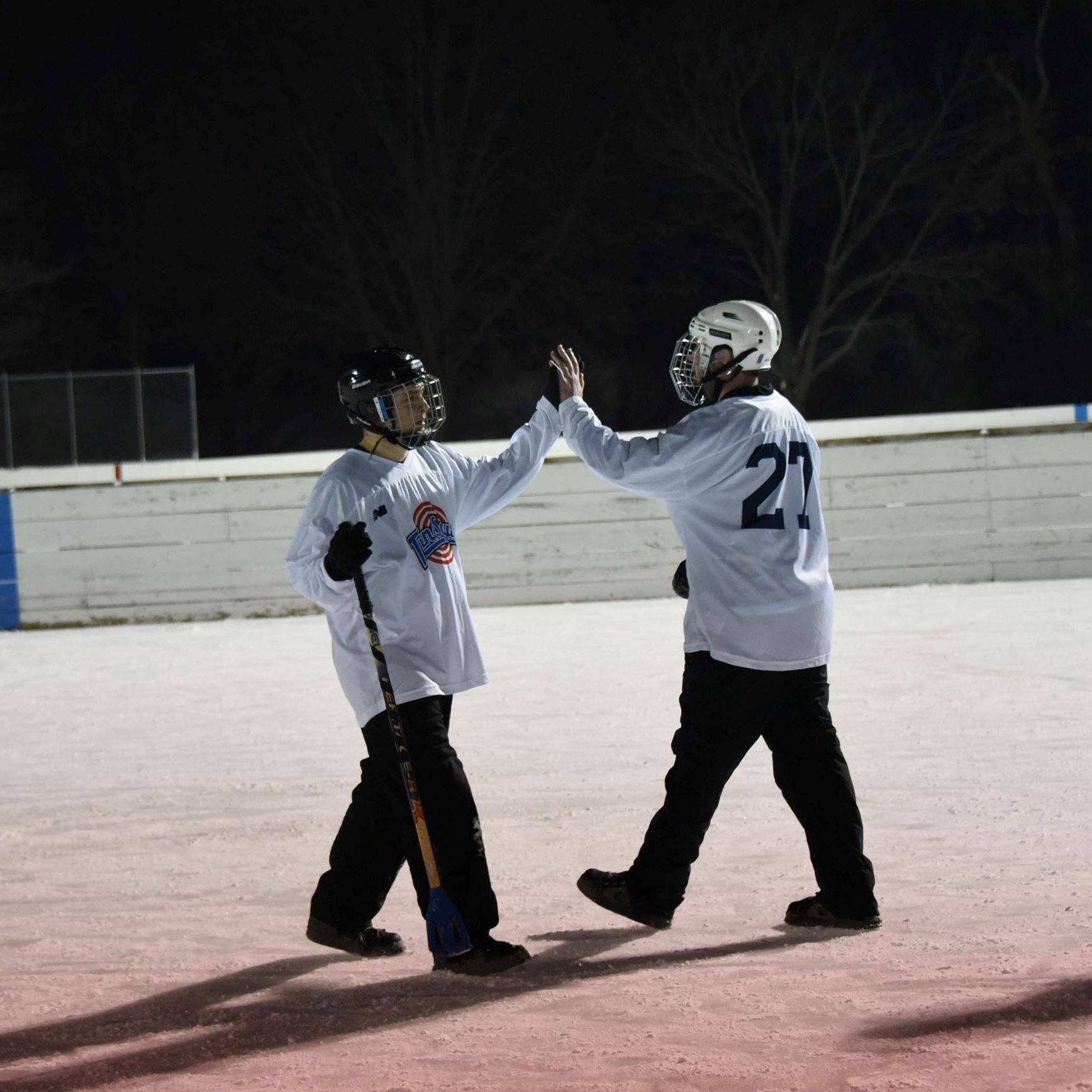 broom ball players giving a high five