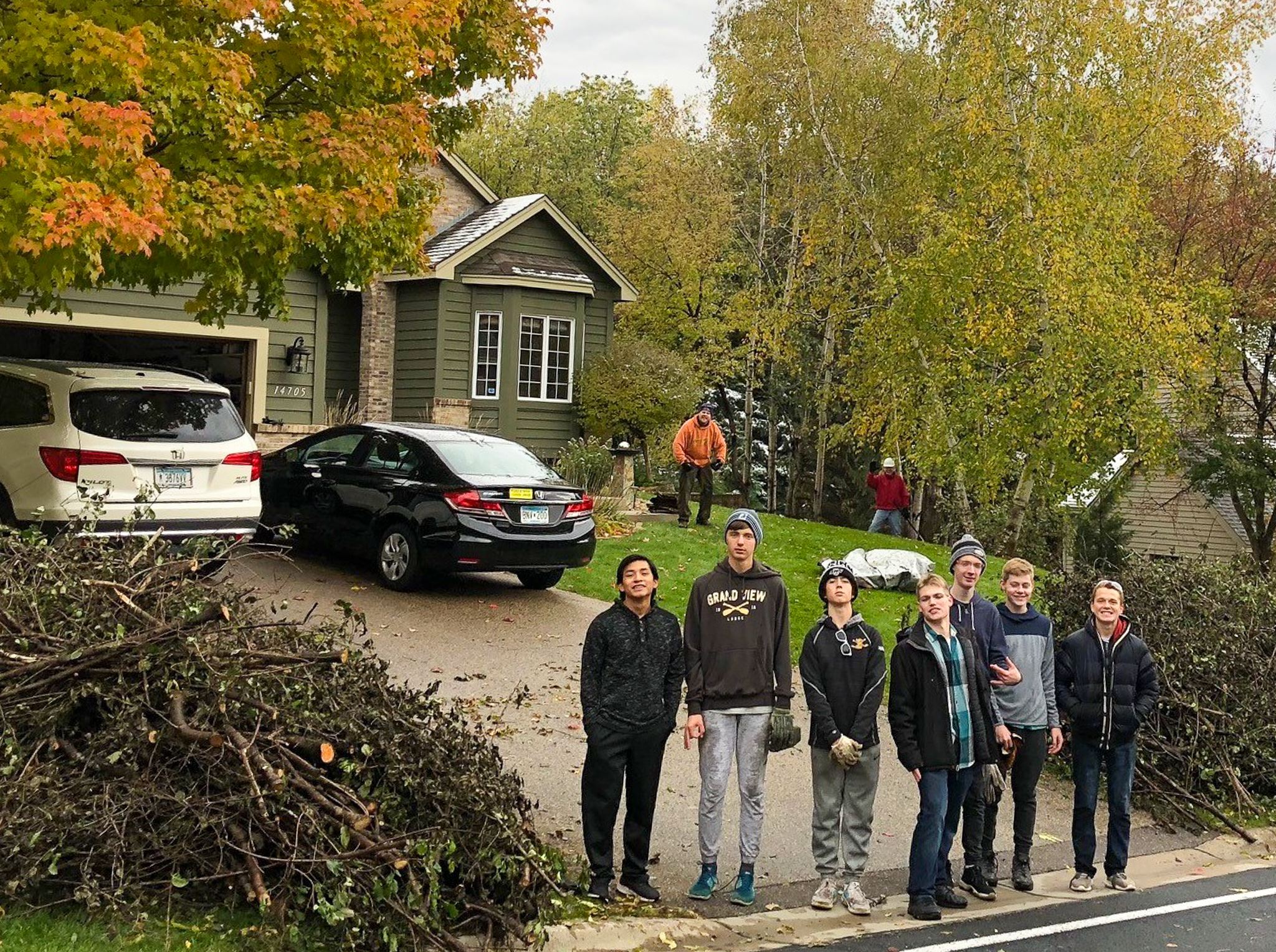 Group of people in front of their residential buckthorn pick up pile